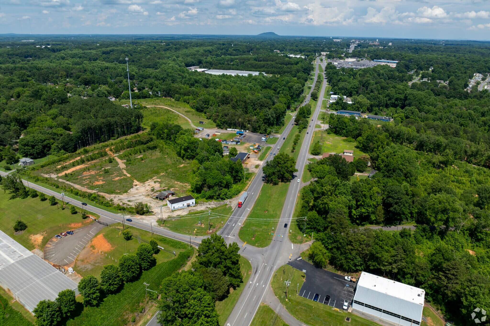 Aerial view of commercial land for sale near highway - ideal location to build self storage units with high visibility and easy access